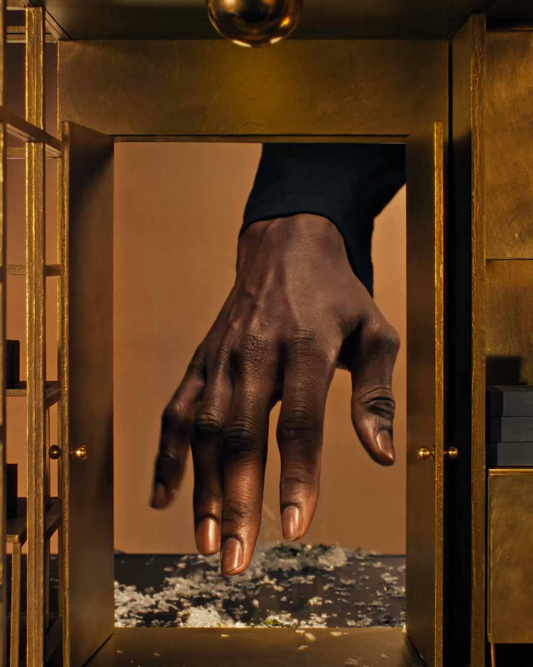 A hand entering through a door