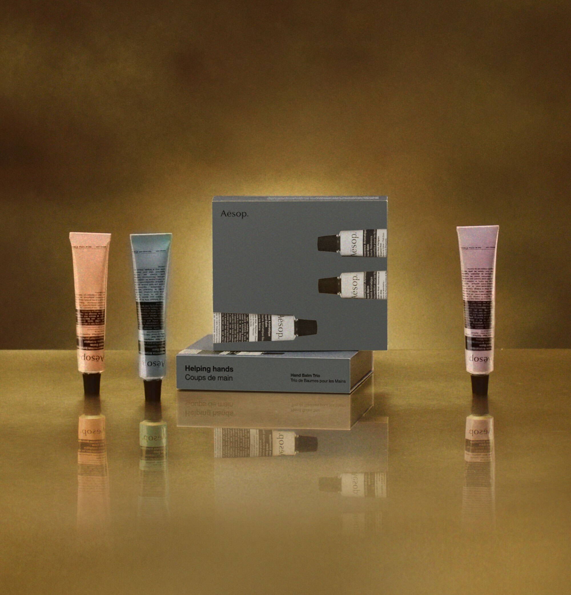 3 Aesop hand balms placed next to a gift box
