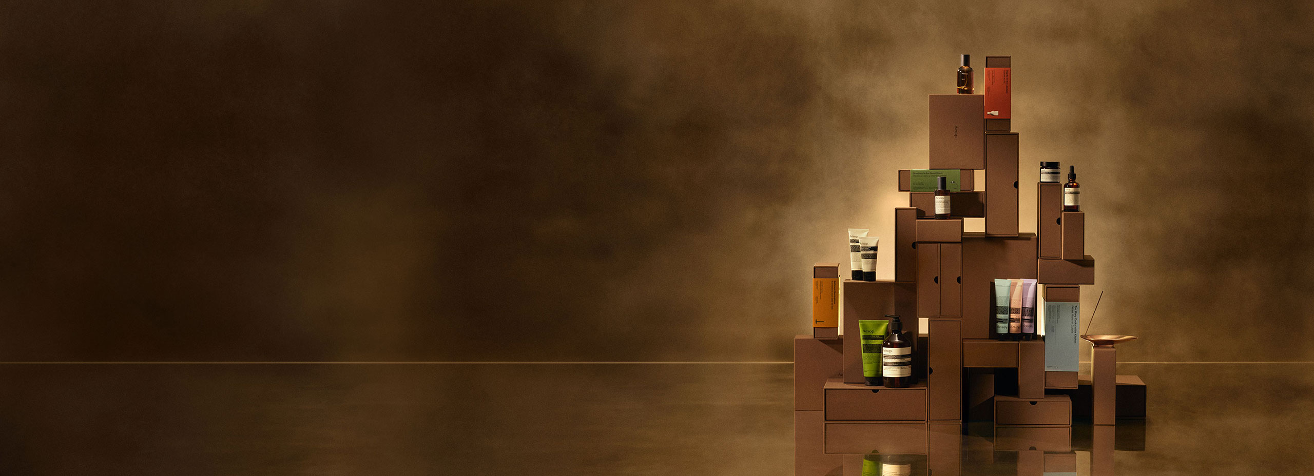 Aesop festive gift kits built into a tower on a brass countertop.