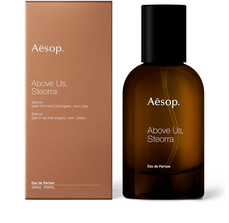 An amber glass bottle of Above Us, Steorra Eau de Parfum alongside brown carton packaging.