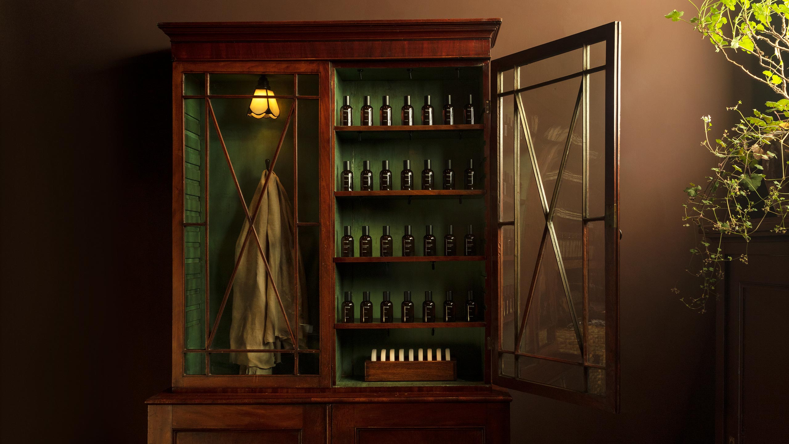 A timber and glass cabinet filled with amber bottles.
