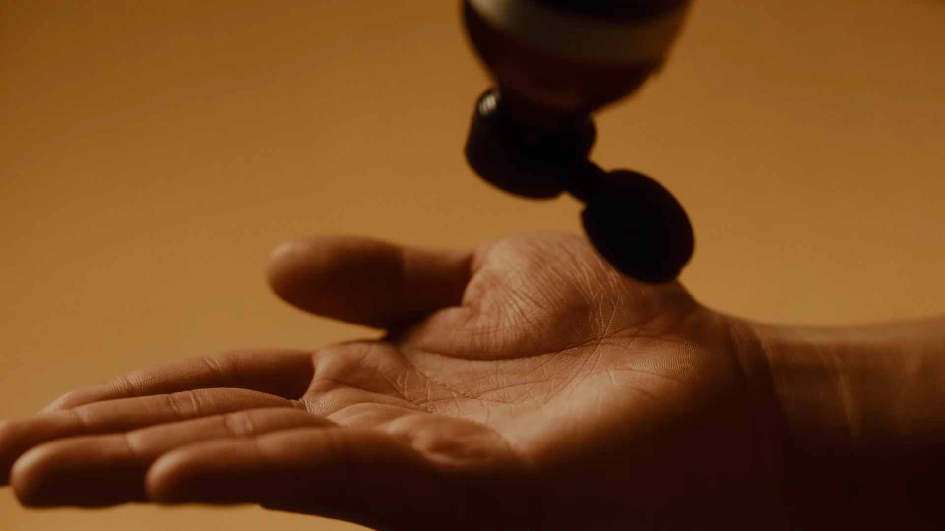 A person applying toner to their face.